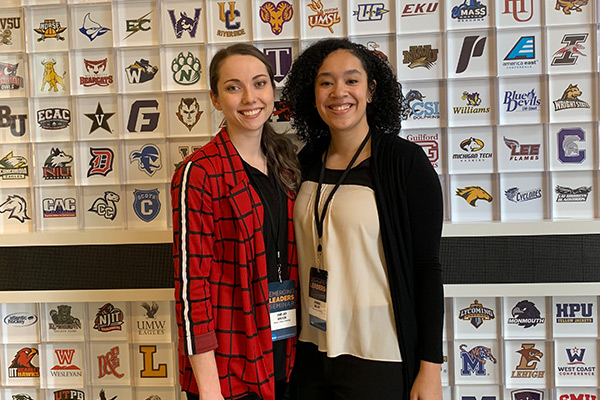 girls posing my logo wall 1